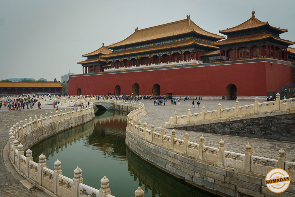Vista de la entrada monumental a la Ciudad Prohibida en Pekín, China, con canales de agua, turistas y arquitectura imperial