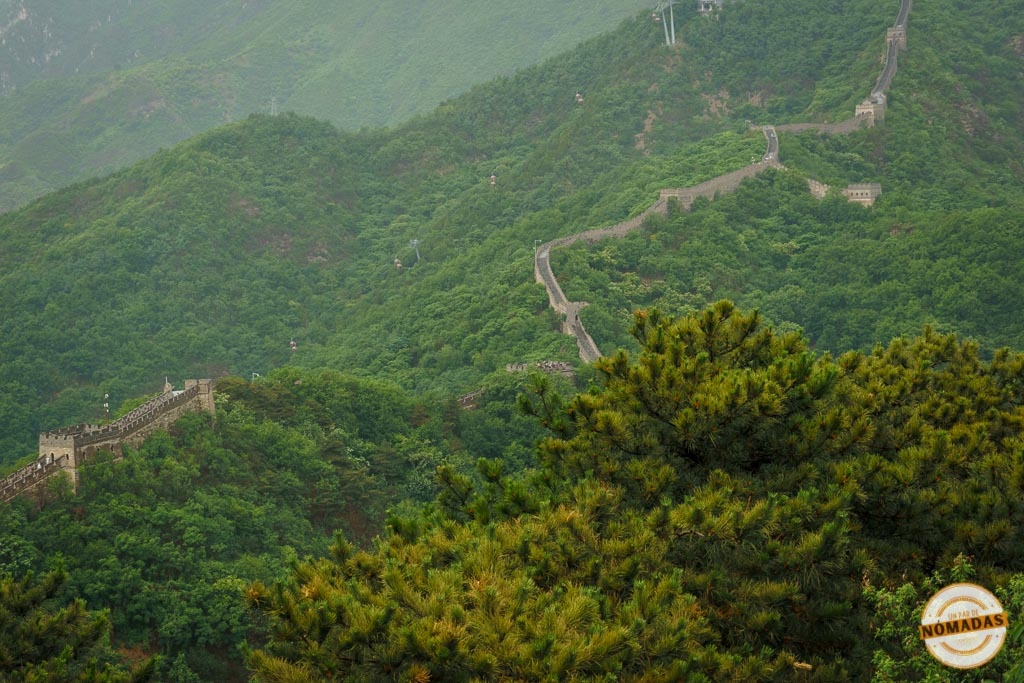 Vista aérea de la Gran Muralla China serpenteando entre colinas verdes en la zona de Mutianyu