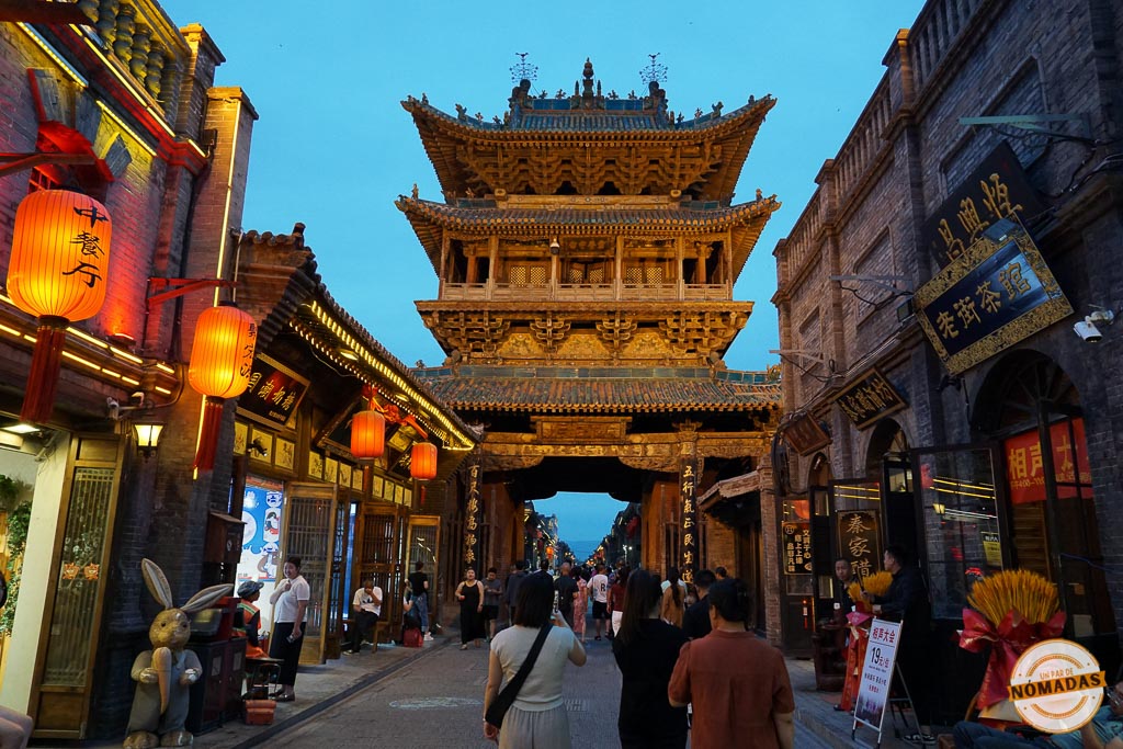 Torre principal iluminada al fondo de la Calle Ming-Qing en Pingyao, rodeada de faroles y comercios tradicionales