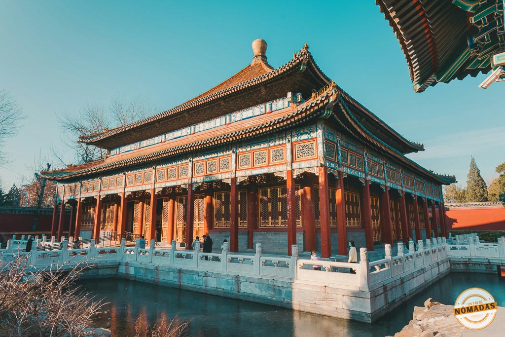 Pabellón tradicional chino en Huaqing Hot Springs, reflejado sobre el agua, con detalles arquitectónicos coloridos y luz de tarde