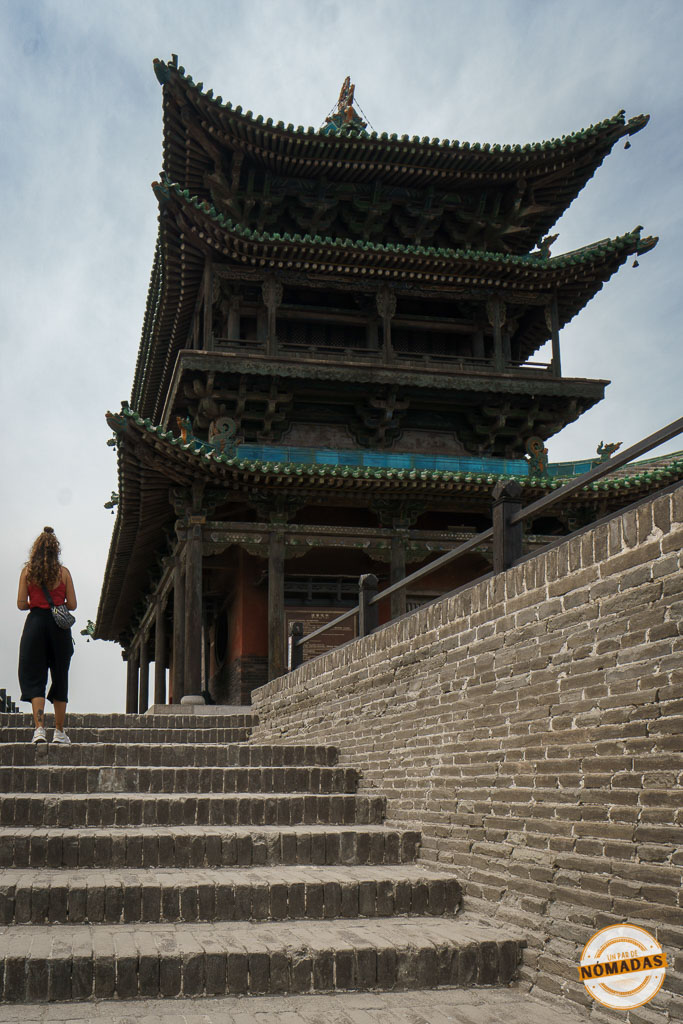 Tatiana subiendo las escaleras hacia una torre de vigilancia en la muralla de Pingyao, construcción defensiva tradicional china