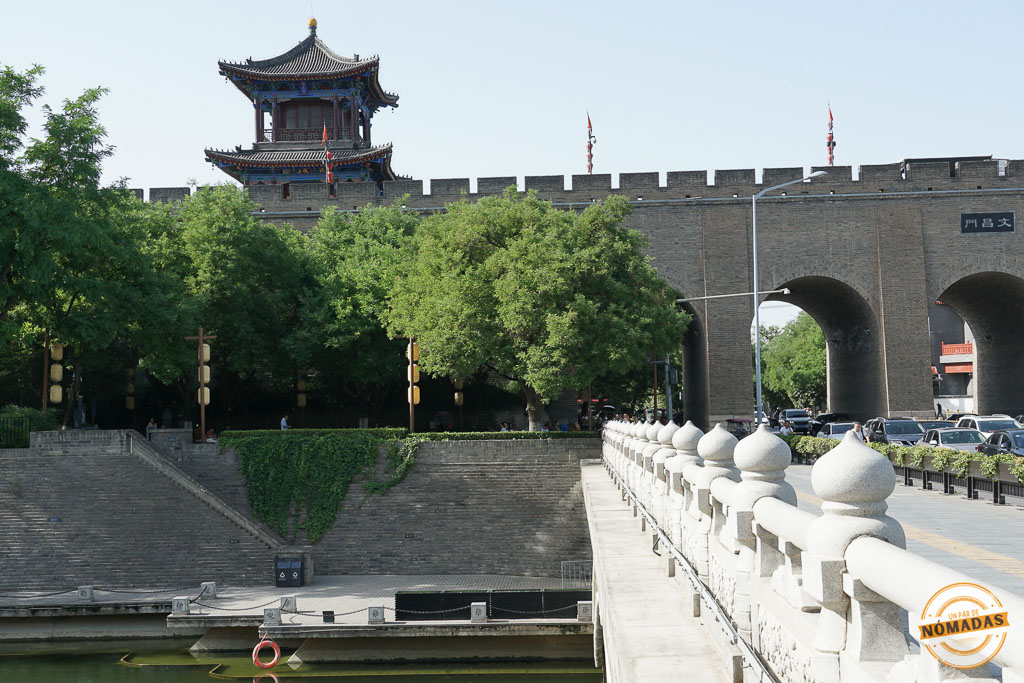 Puerta Sur de la Muralla de Xi’an con su torre defensiva, árboles frondosos y el foso a sus pies en un día soleado