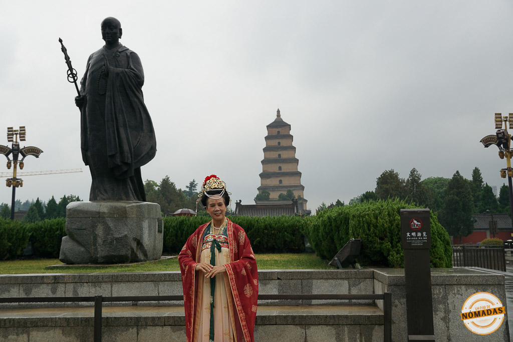 Mujer con vestimenta tradicional china frente a la estatua del monje Xuanzang y la Pagoda del Ganso Salvaje en Xi’an