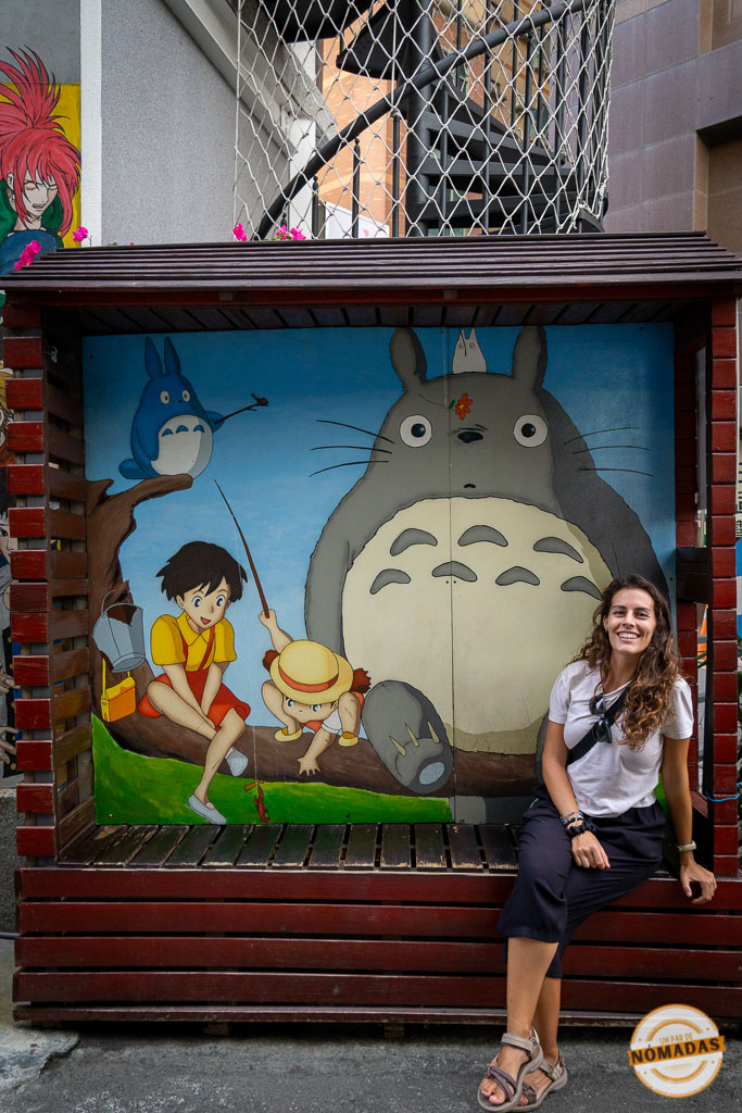 Mujer sonriendo junto a un mural del personaje Totoro en Taichung