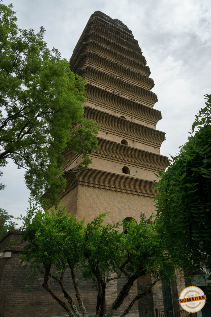 Vista de la Pequeña Pagoda del Ganso Salvaje en Xi’an rodeada de árboles y cielo nublado, destacando su arquitectura en ladrillo