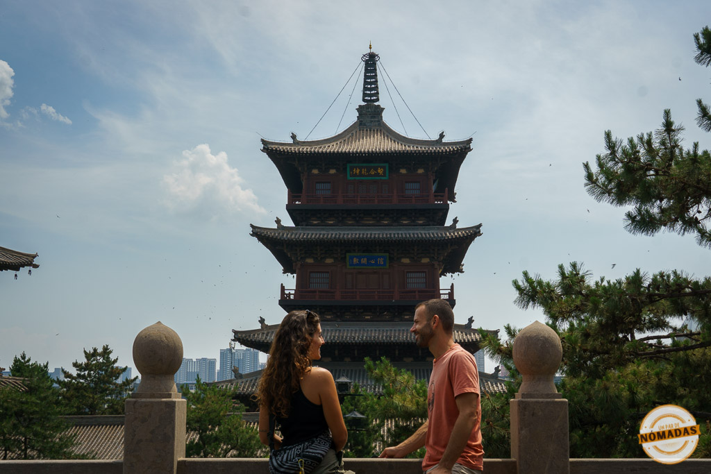 pareja viajera frente a una pagoda tradicional china, ideal para hablar del presupuesto del viaje