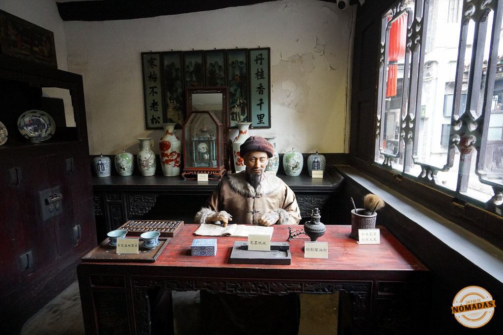 Recreación histórica del interior del Primer Banco de China en Pingyao, con figura tradicional tras un escritorio antiguo
