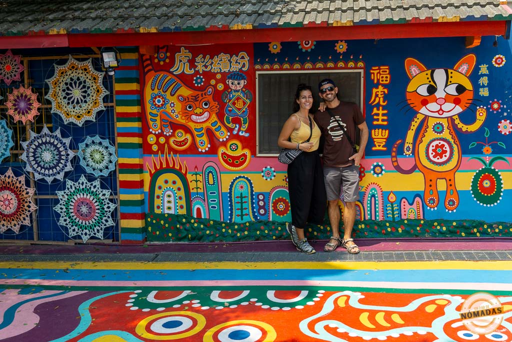 Pareja frente a un mural colorido en el Rainbow Village, una atracción artística en Taichung