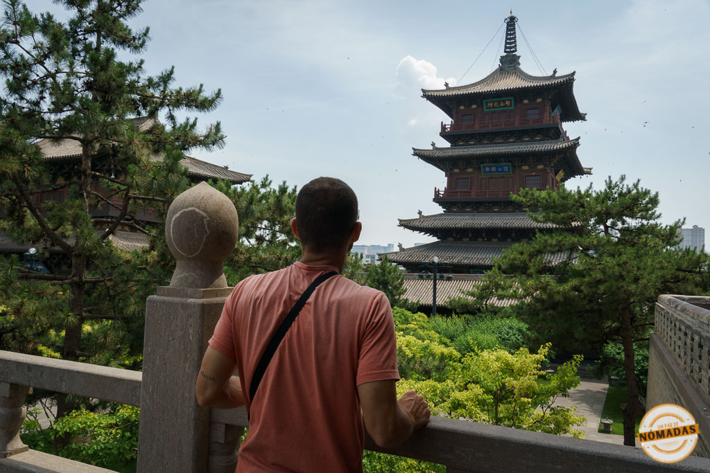 Qué ver en Datong en 2 días: viajero contemplando la pagoda principal del Templo Huayan rodeada de jardines