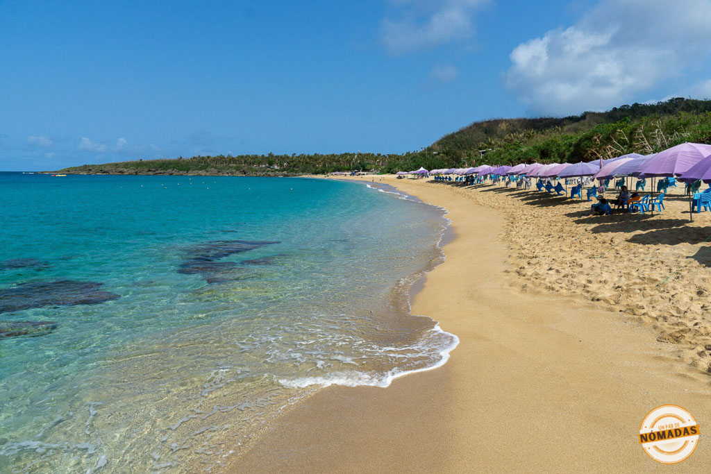 Playa Baishawan de arena dorada y sombrillas en fila junto al mar turquesa