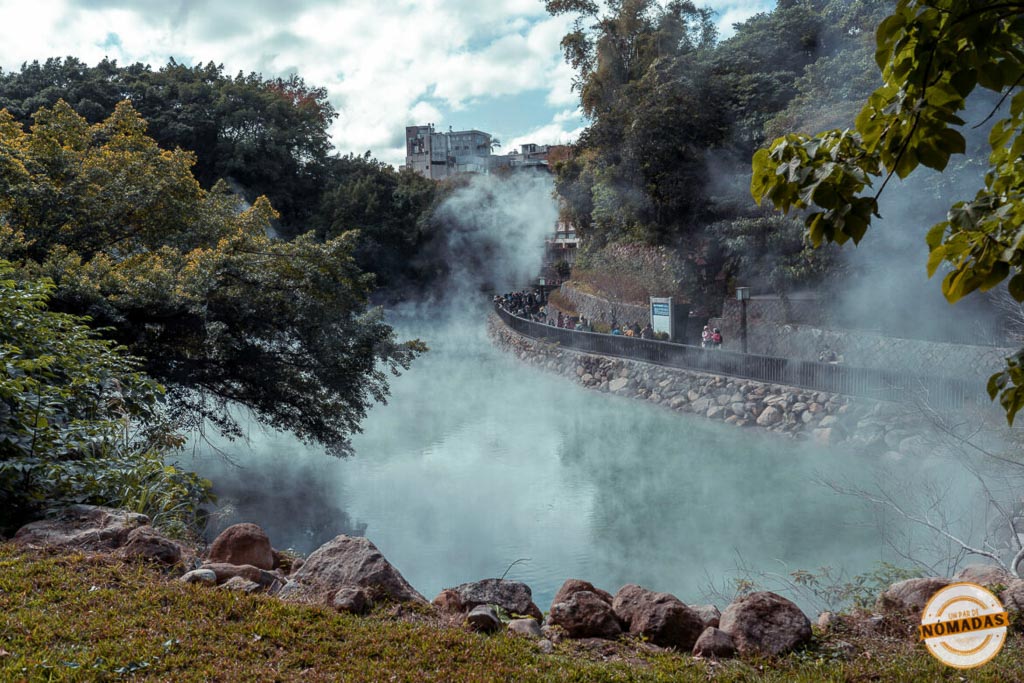 Vapor saliendo de las aguas termales de Beitou, rodeadas de vegetación y senderos en Taipéi.