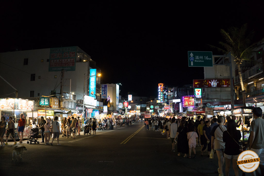 Multitud paseando entre puestos iluminados en el mercado nocturno de Kenting