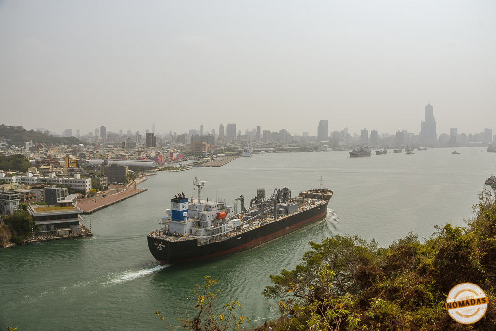 Barco de carga navegando frente al skyline del puerto de Kaohsiung, uno de los sitios que ver en Kaohsiung en 2 días
