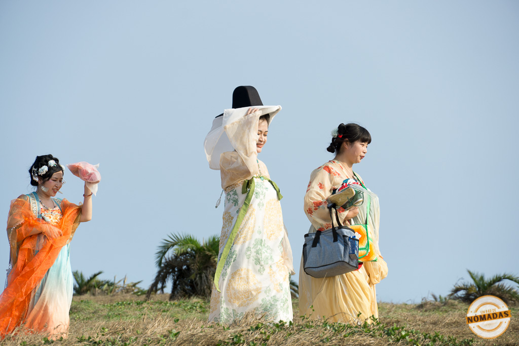 Tres mujeres taiwanesas con trajes tradicionales en un campo cerca de Kenting