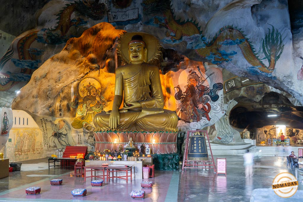 Gran estatua dorada de Buda en el interior del templo Perak Cave con pinturas murales