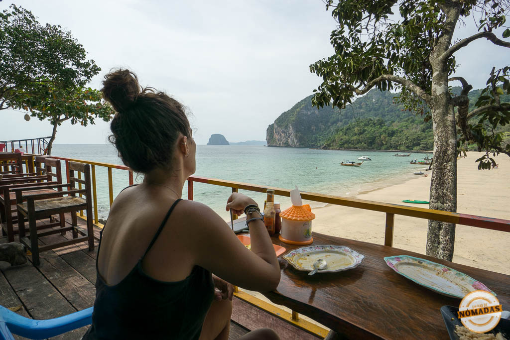Tatiana sentada en un restaurante frente a la playa en Koh Mook, Tailandia, con vistas al mar y a los acantilados de Charlie Beach