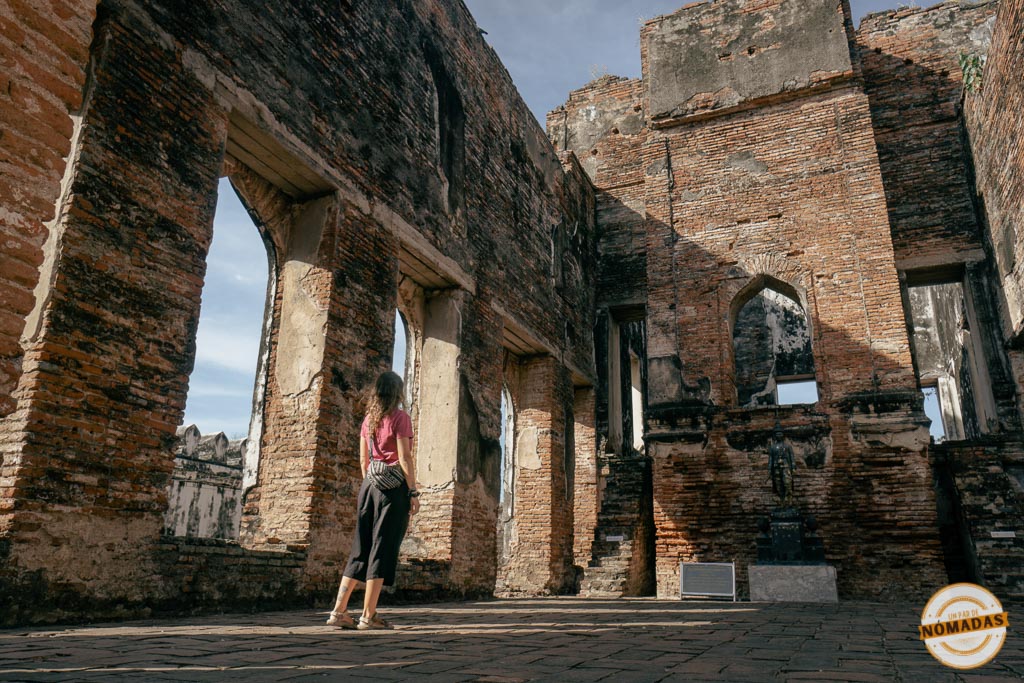 Tatiana camina entre las paredes derruidas de un antiguo templo en Lopburi