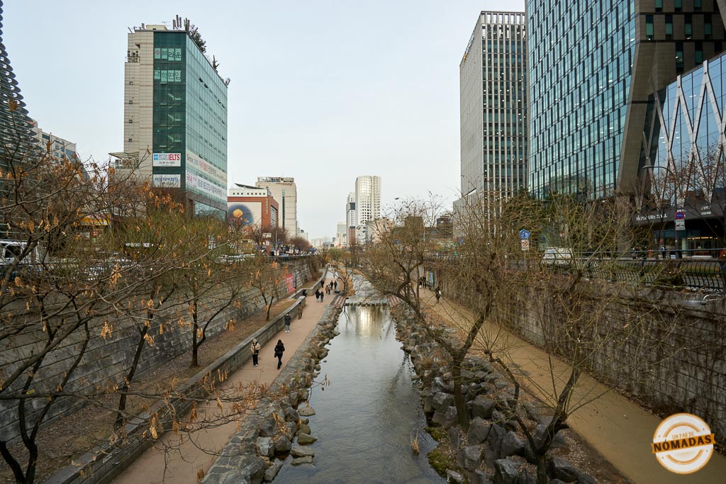 Camino peatonal junto al arroyo Cheonggyecheon entre edificios modernos de Seúl