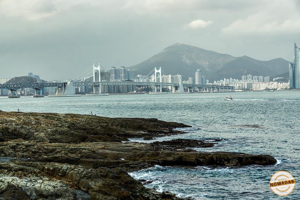 Vista del puente Gwangan en Busán al atardecer desde la costa rocosa, ideal para cerrar una ruta de viaje por la ciudad

