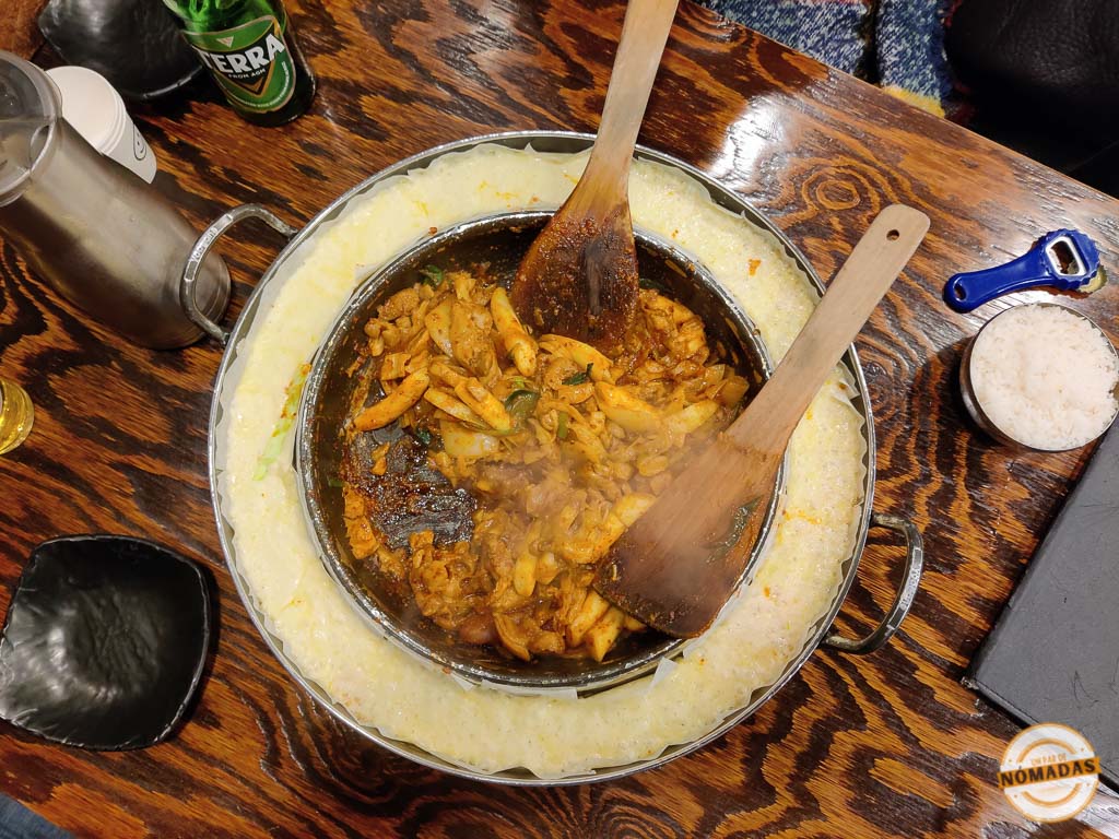 Plato coreano de Dak Galbi servido en el Mercado de Gwangjang de Seúl, rodeado de queso derretido