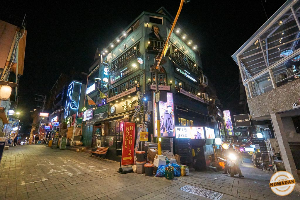Calle iluminada de Itaewon en Seúl por la noche, con bares y carteles de neón