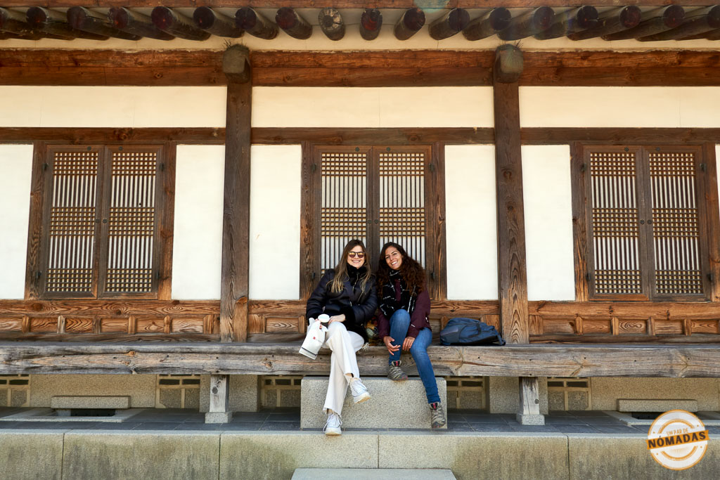 Tatiana y Laura sentadas frente a una casa tradicional coreana en el Museo de Historia de Seúl