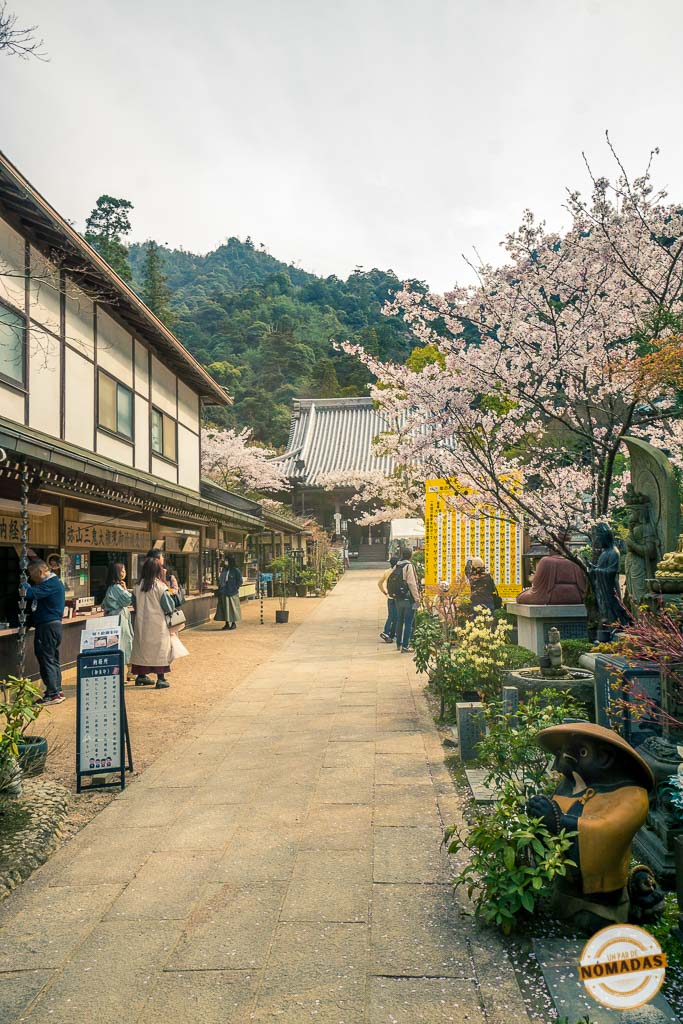 Calle tradicional de Miyajima con puestos de souvenirs y cerezos en flor durante la primavera, en la zona comercial de Omotesando