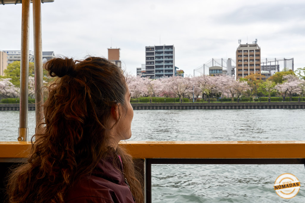 Tatiana mirando los cerezos en flor desde un crucero por el río Okawa. Una de las cosas imprescindibles que hacer en Osaka

