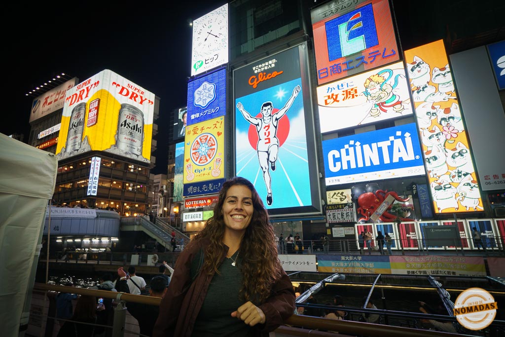 Tatiana sonriendo frente al luminoso cartel de Glico en Dotonbori, uno de los iconos más representativos de Osaka por la noche
