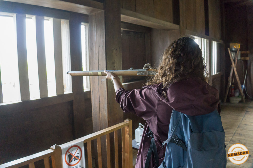 Tatiana apuntando con una réplica de arcabuz desde el interior de las defensas del castillo de Osaka, parte del patrimonio cultural japonés
