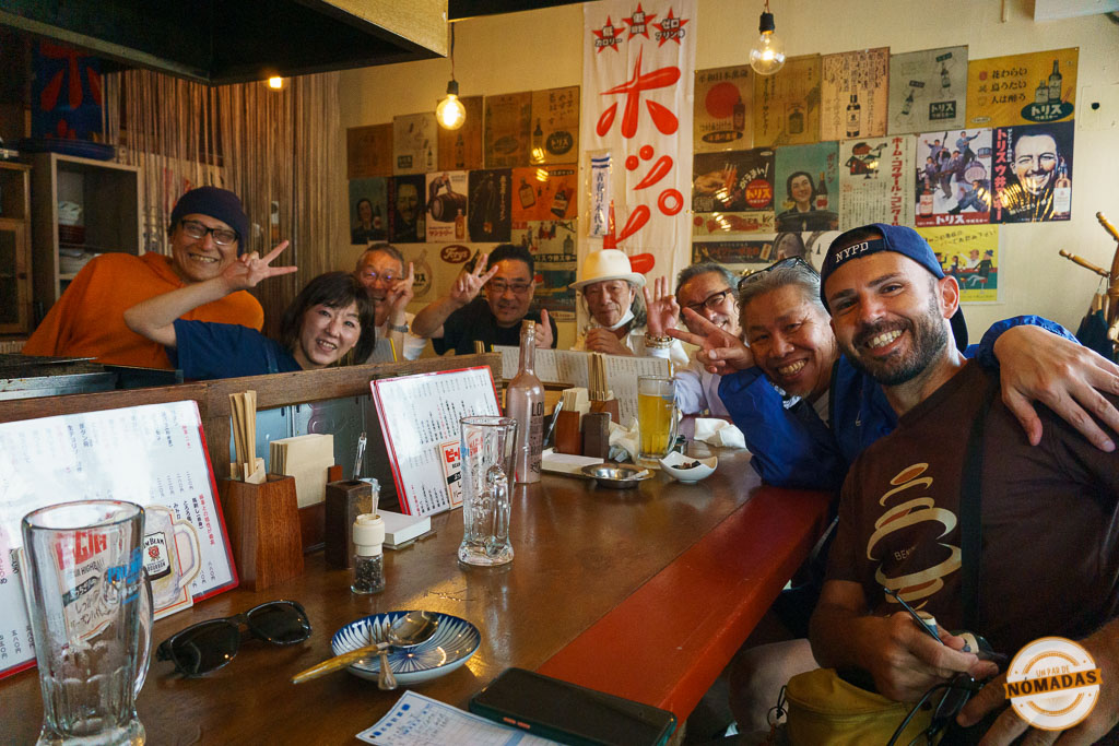 Grupo de japoneses y Oscar compartiendo cena y cervezas en una izakaya