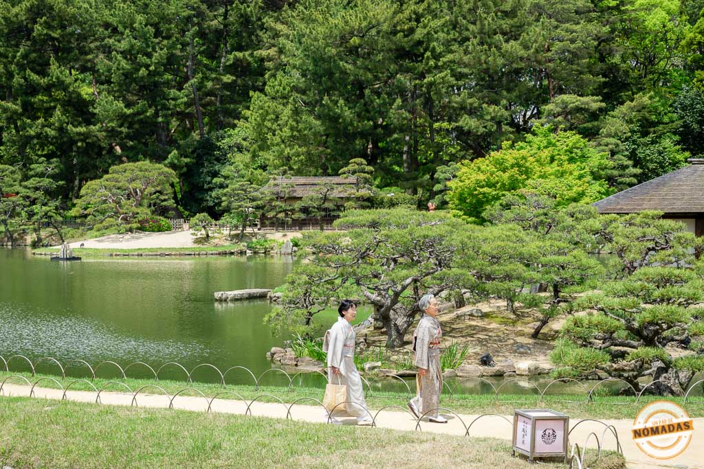 Dos mujeres con kimono caminando junto al estanque del jardín Kōrakuen en Okayama