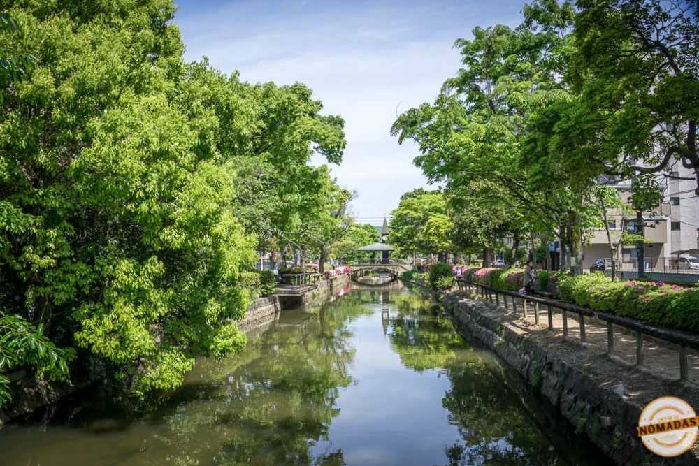 Vista del canal Nishigawa en Okayama rodeado de árboles y puentes
