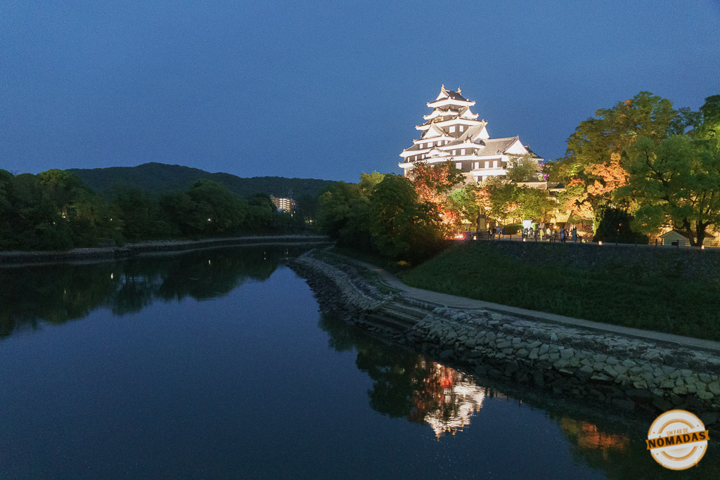 Castillo de Okayama iluminado y reflejado sobre el río en una noche clara