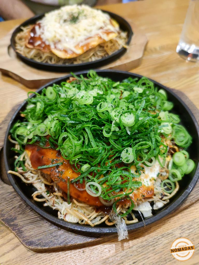 Plato de okonomiyaki con abundante cebolleta servido caliente en Hiroshima