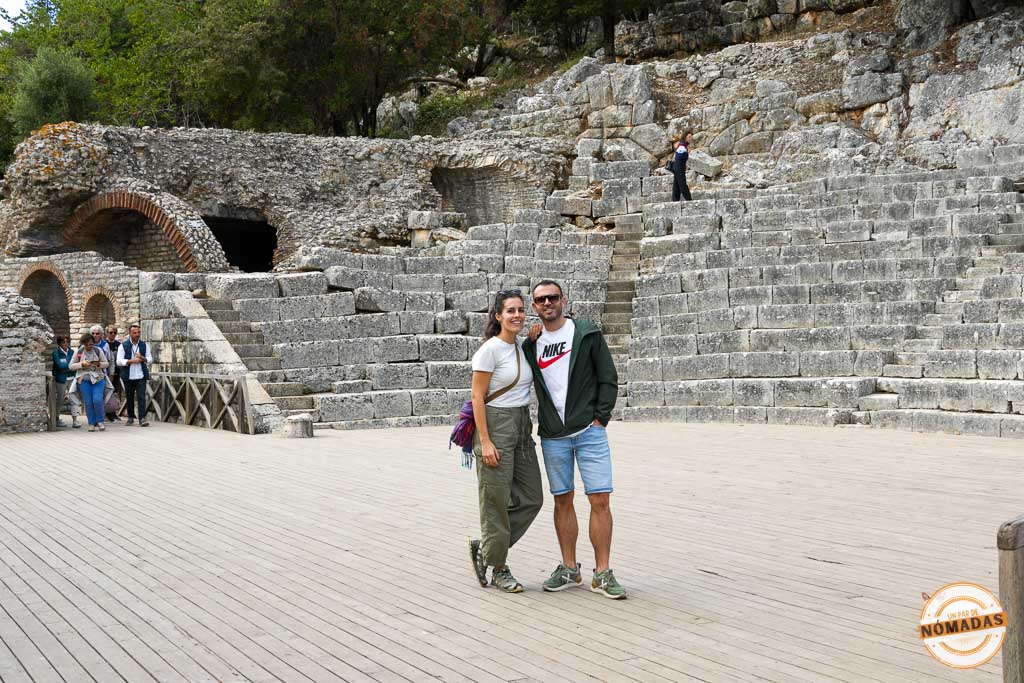 Pareja de viajeros posando en el escenario del antiguo teatro del Parque Nacional de Butrinto, Albania.