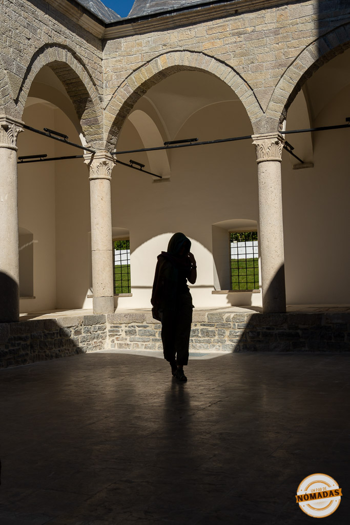 Silueta de una mujer caminando bajo los arcos de piedra del patio interior de la Mezquita de Plomo en Shkodër.