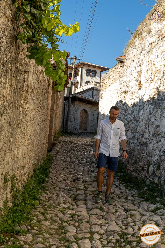 Hombre paseando por una callejuela empedrada dentro de las murallas del Castillo