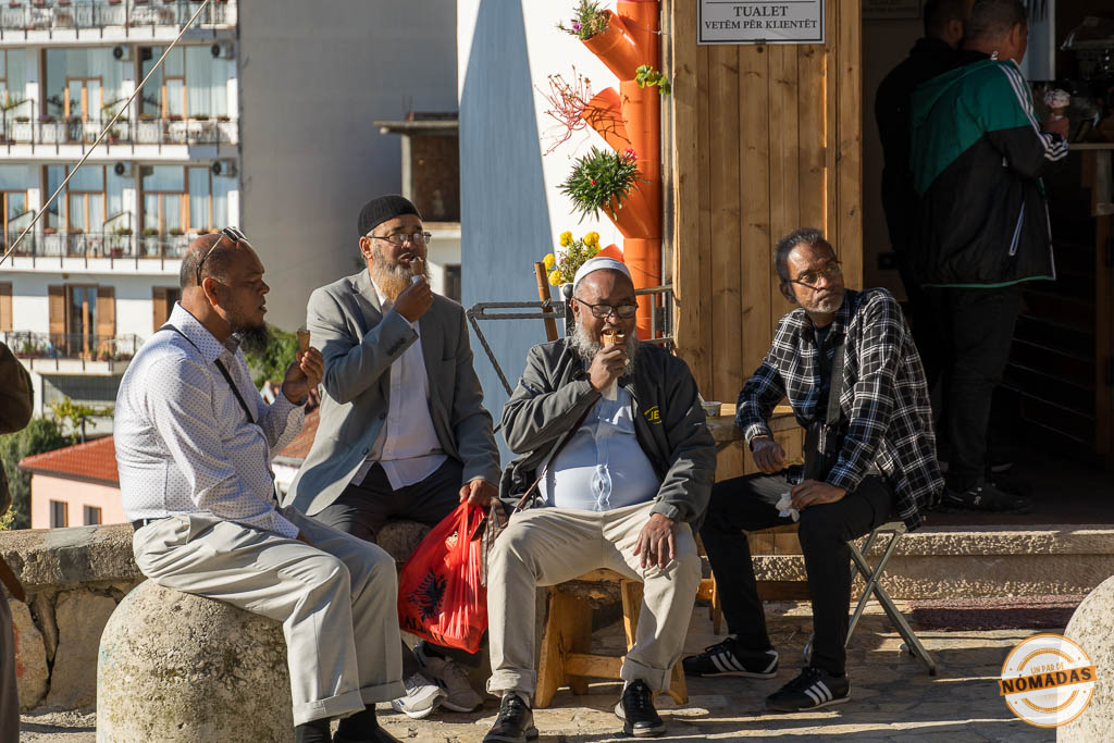 Grupo de hombres locales sentados en una calle de Krujë, una escena de la vida cotidiana que ver en la ciudad.