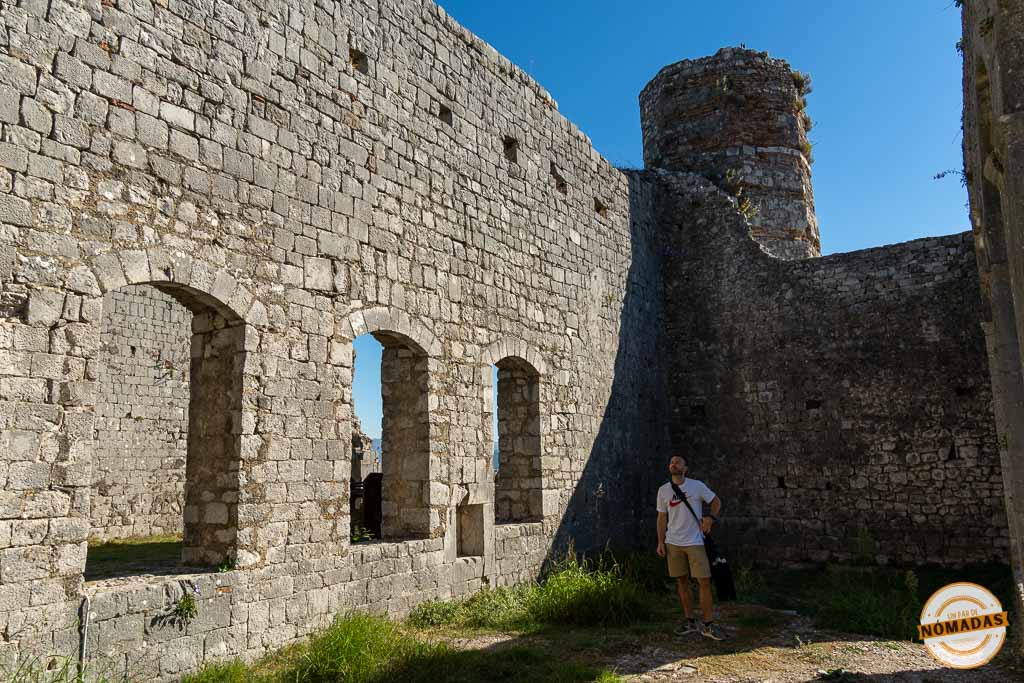 Viajero explorando los muros de piedra y arcos del interior del Castillo de Rozafa en Shkodër.