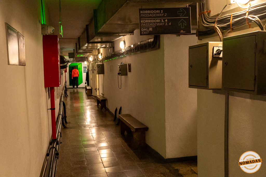 Pasillo estrecho de hormigón con tuberías y señalización en el interior del museo subterráneo Bunk'Art 2 en Tirana.