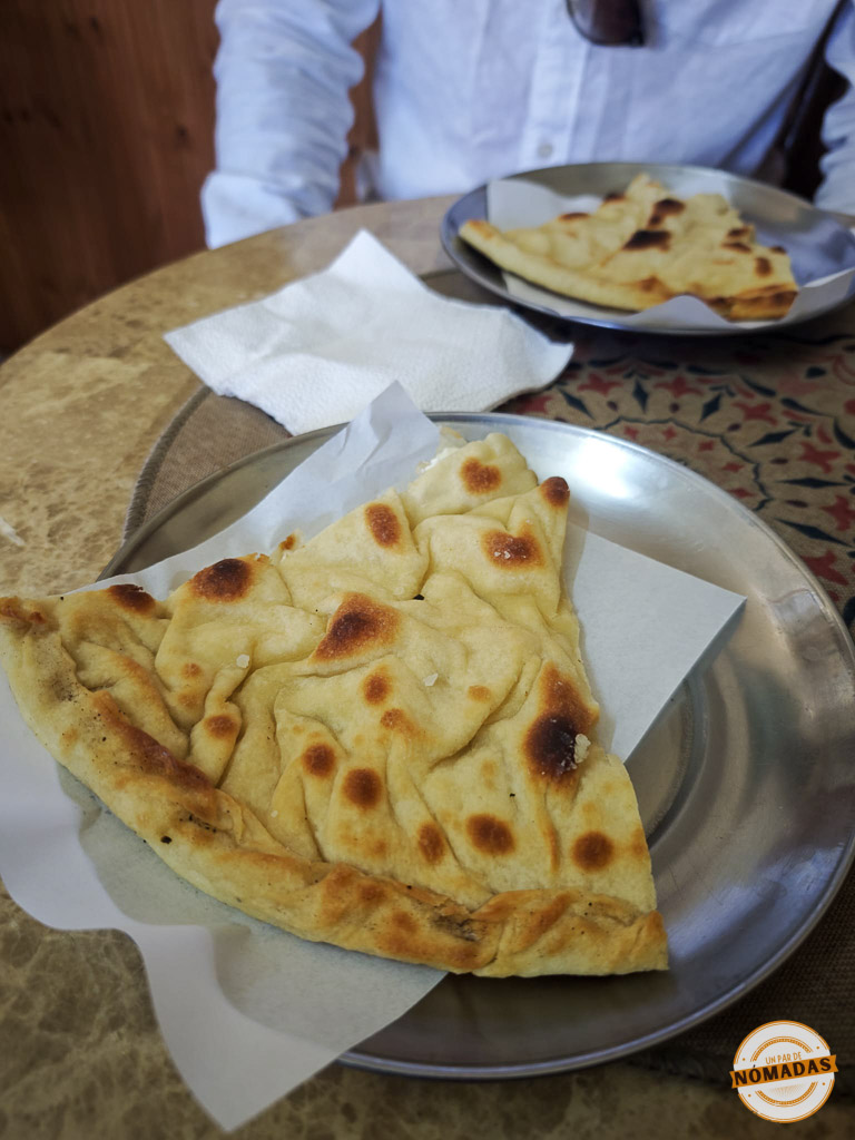 Primer plano de una porción triangular de Lakror, un pastel salado tradicional albanés, servido en un plato de metal en el restaurante Lakror Te'Ela.