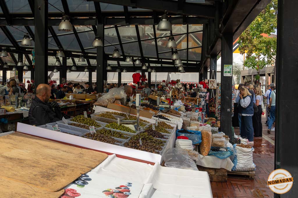 Puestos de aceitunas y productos locales bajo el techo de cristal y acero del mercado Pazari i Ri en Tirana.
