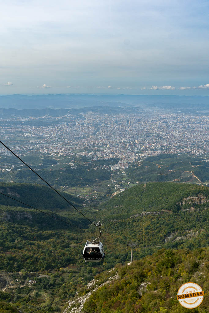 Cabina del teleférico Dajti Ekspres suspendida sobre la montaña, con una vista panorámica impresionante de la ciudad de Tirana al fondo.
