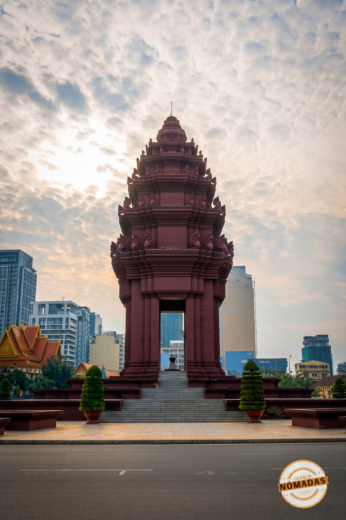 Imponente Monumento a la Independencia con forma de flor de loto contrastando con los modernos rascacielos, un símbolo histórico imprescindible que ver en Phnom Penh.