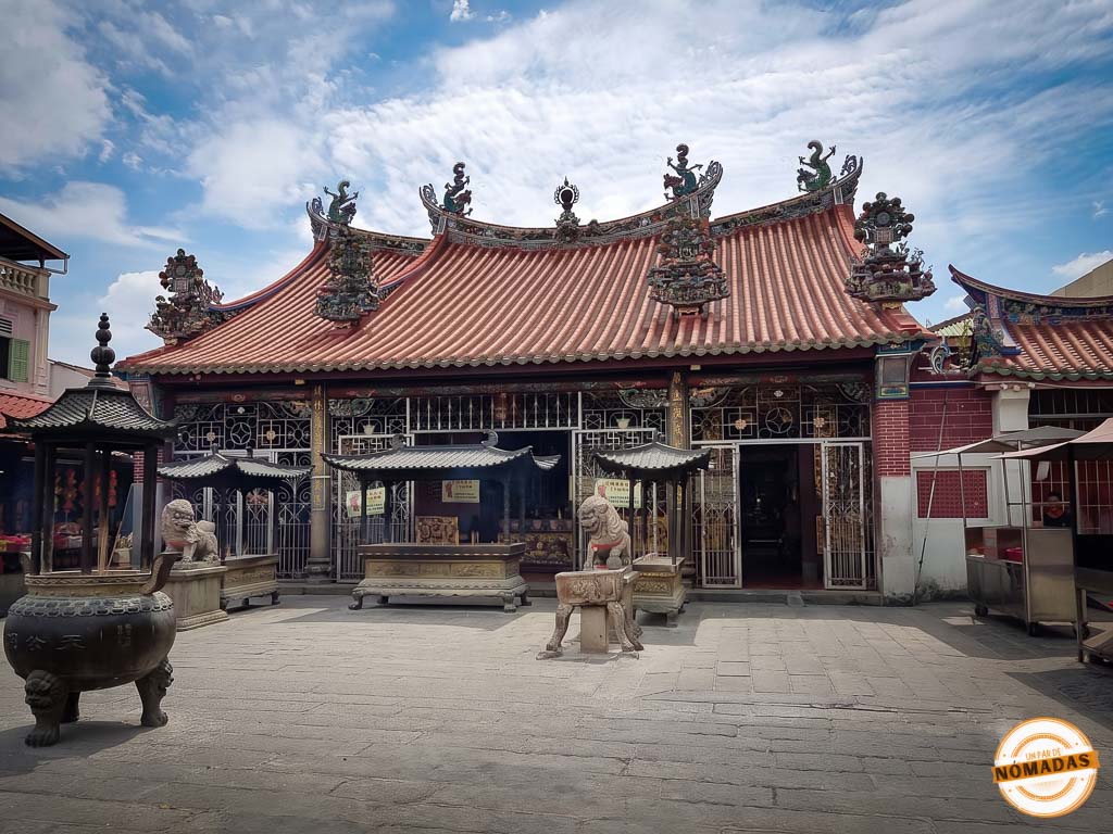 Patio exterior y fachada principal del histórico templo chino Kuan Yin en Georgetown, Penang, destacando su característico tejado de tejas naranjas ornamentado con dragones y grandes quemadores de incienso.